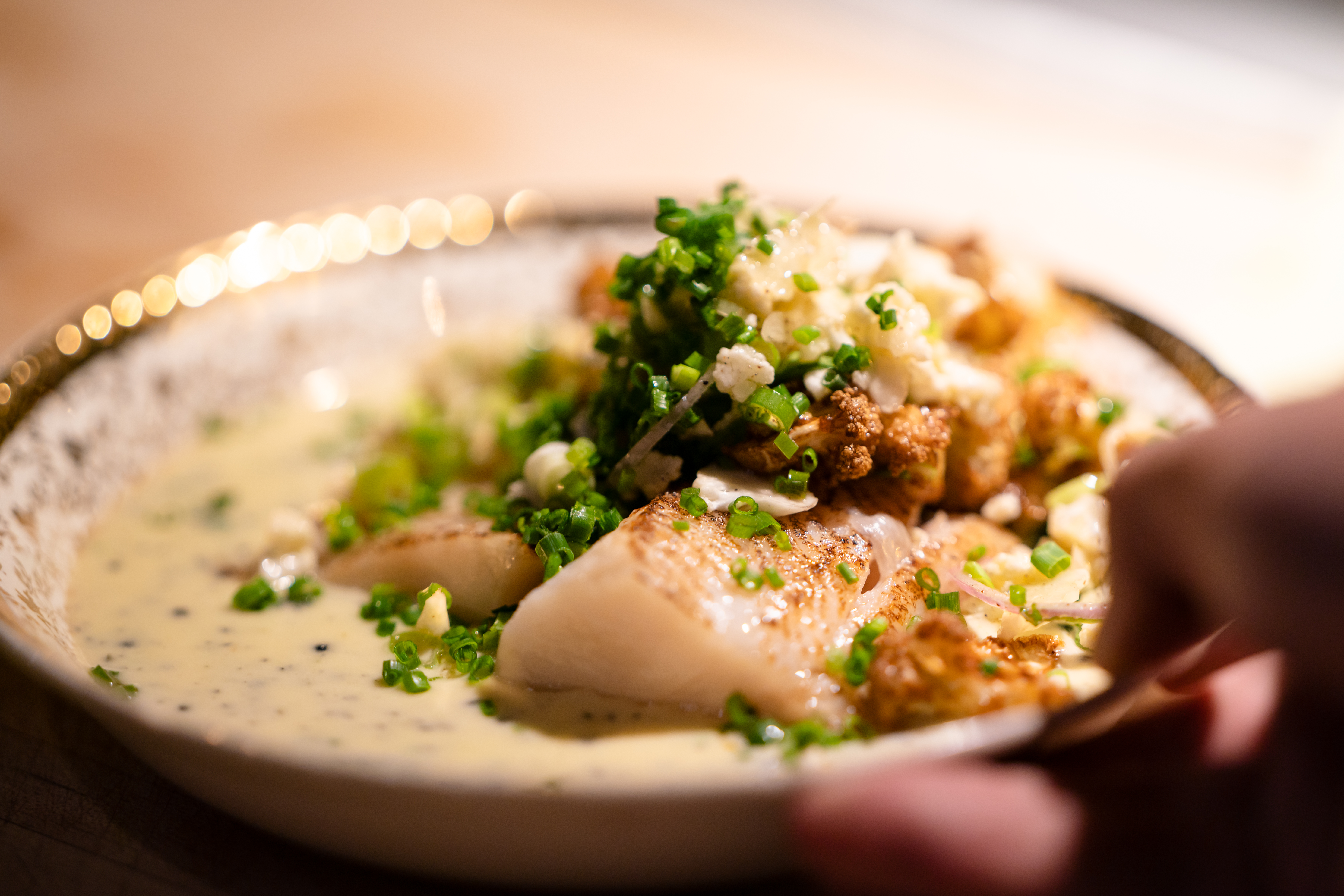 Poisson saisi, chou-fleur rôti et ciboulette, servi à la table du BRUT.